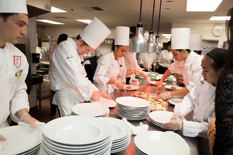 Students preparing food in the kitchens at the 88th (2013) Hotel Ezra Cornell Gala Banquet.