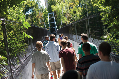 Incoming students on a Fall Creek Gorge hike cross the Suspension Bridge.