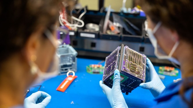 The Padres sisters examine Alpha CubeSat (a light sail-carrying, cube-shaped satellite) in the Space Systems Design Studio Lab in Rhodes Hall.