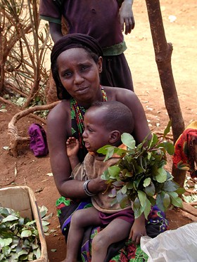 A woman holds her child in the village of Dirib Gombo
