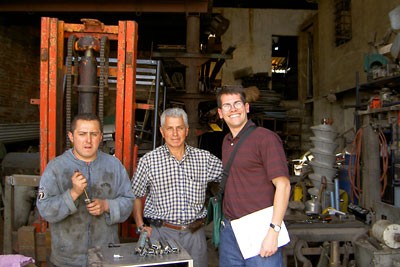 Shon Hiatt, right, with a father and son who run a metal recycling business