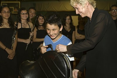 Cynthia Johnston Turner presents a French horn to a student