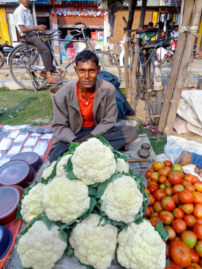 man sells cauliflower and tomatoes