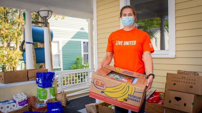 Tompkins County UW volunteer holds box of food