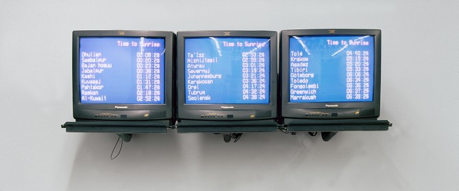 Three televisions side by side mounted on a white wall with blue screens and white text.