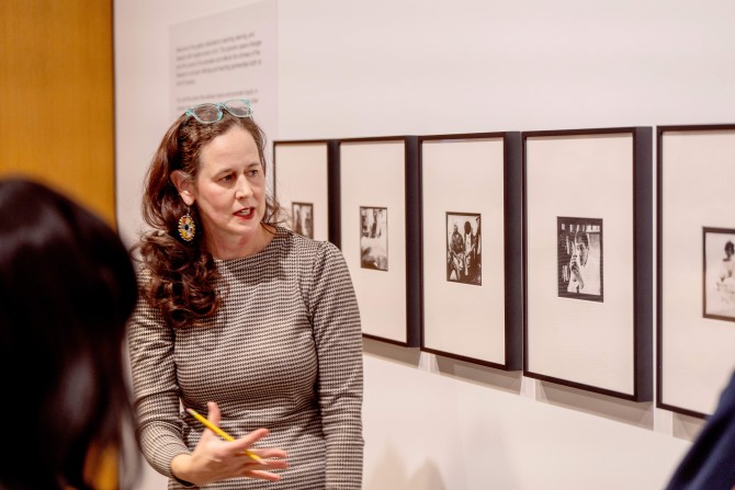 A professor leads a discussion of a museum's photography exhibit. 
