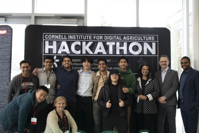 a group of people in front of a sign reading "Hackathon"