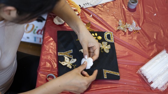 学生们在威拉德·斯特朗大厅的高中活动中装饰毕业帽。