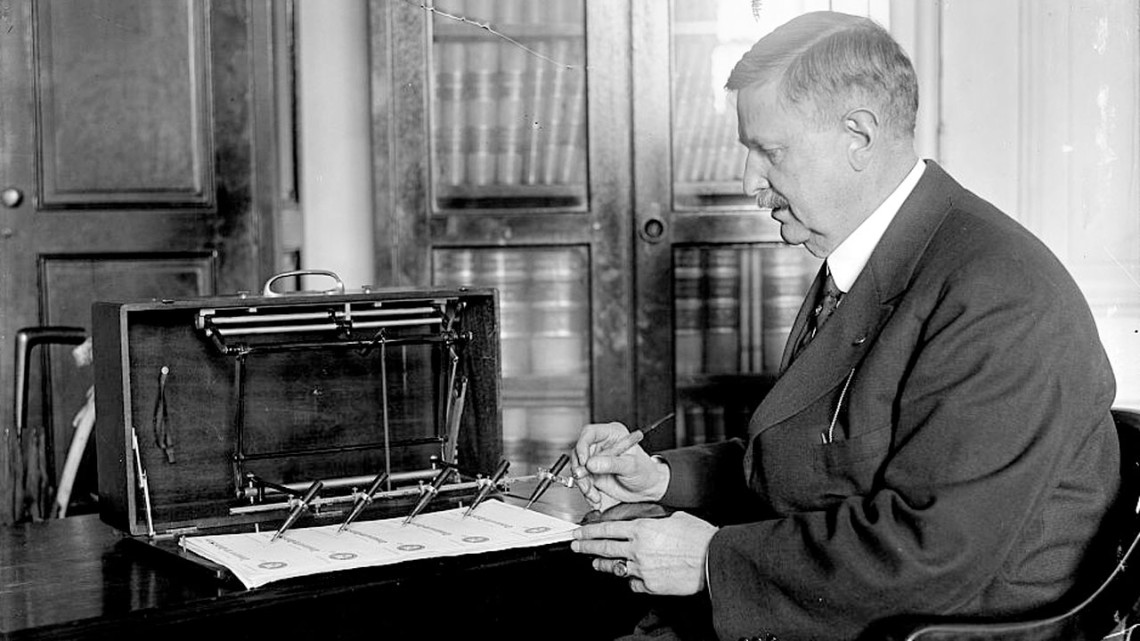 In 1918, J.L. Summers operates a check signing machine in the treasury department, demonstrating an earlier technology to automate signatures.