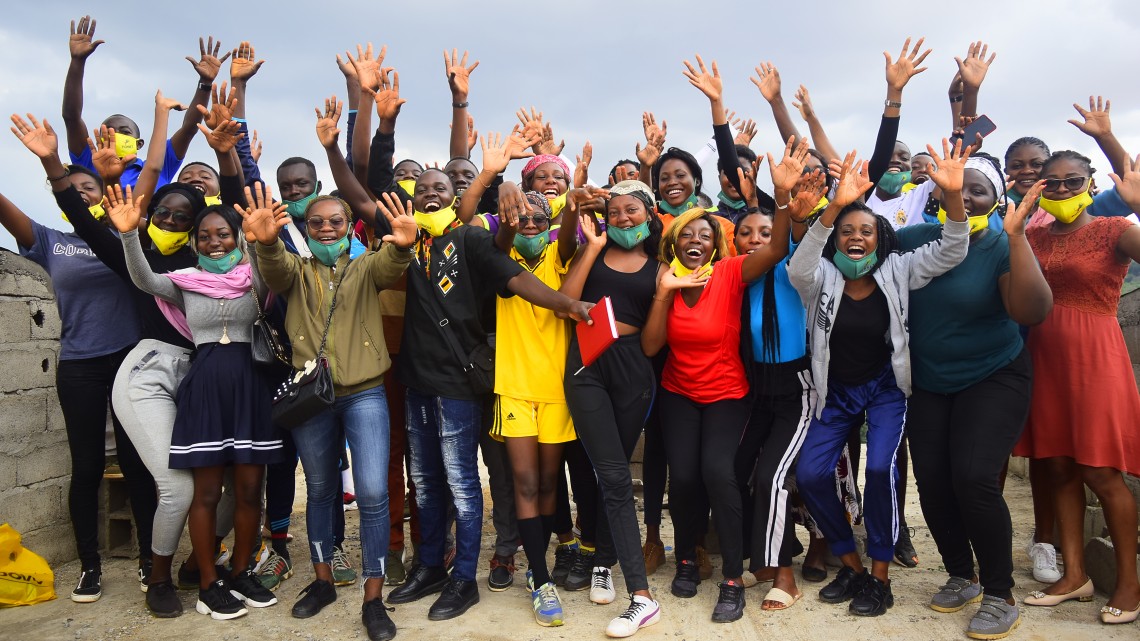 Cameroon students raise their arms and cheer