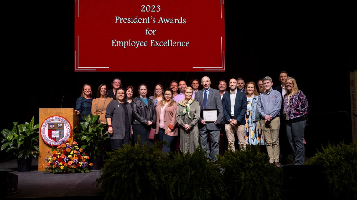 Employees posing with Employee Excellence award