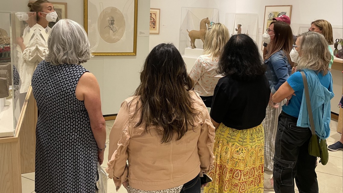 K-12 teachers look at art on the wall of the Johnson Museum.