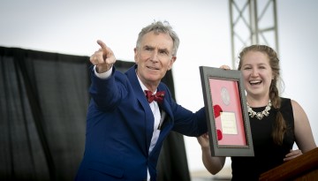 Bill Nye holds medal presented to him. 