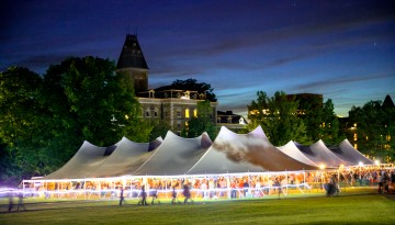 A tent on the Arts Quad lights up at dusk. 