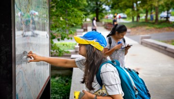A new student checks out the campus map in front of Day Hall. 