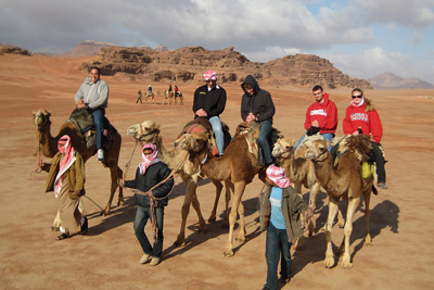 Bedouin guides lead Cornell students on a camelback