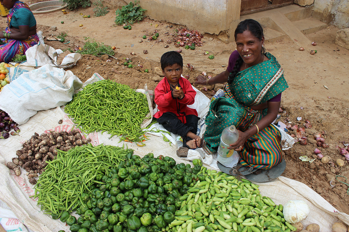woman in a market in India sells fresh produce