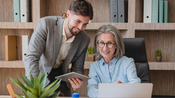 Manager showing financial results to colleague at work