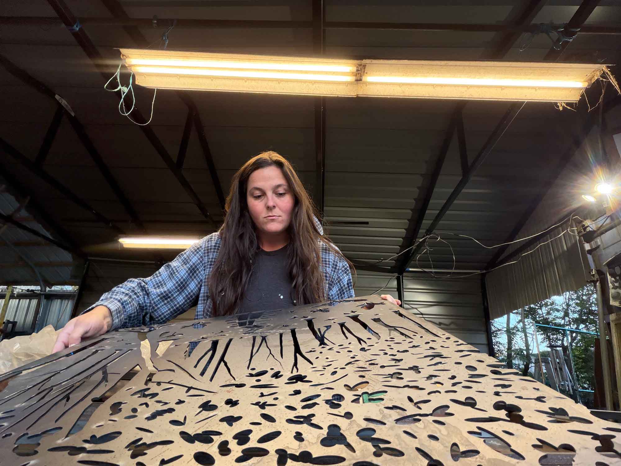 person looking at metal sculpture on table
