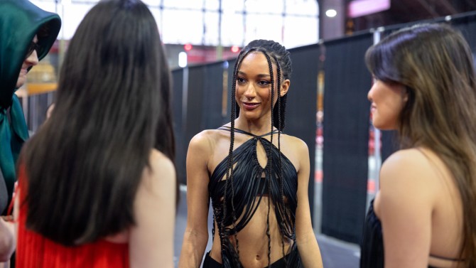 A model wearing a piece from senior Aidan Collins’ collection chats with fellow models ahead of the 2023 fashion show in Barton Hall. 