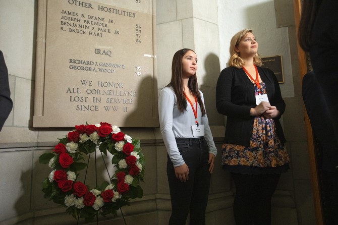 At a 2019 ceremony, Maria Gannon, left, and Maria Wood stand beside the war memorial plaque in the Anabel Taylor Hall rotunda that honors their fathers, Marine Maj. Richard J. Gannon II ’95 and Army Capt. George A. Wood ’93.