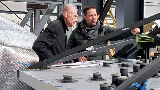 Karl Steeger, right, vice president and director of engineering at CPI-Vertex, explains the mechanical design of the mirror backup structure to Fred Young.