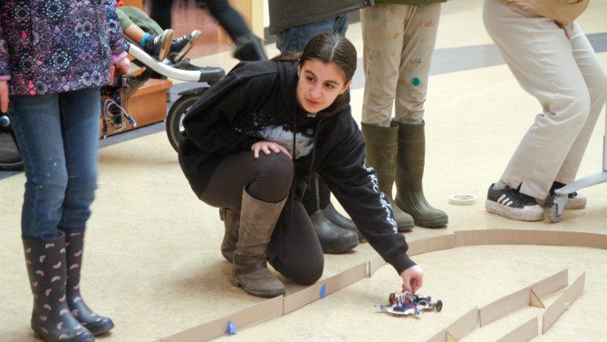 Students race their cars down the main hallway of the Tompkins County Public Library during a recent outreach workshop.