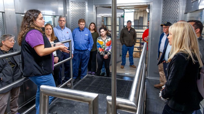 Ananda Portela Fontoura, postdoctoral associate in the Department of Animal Science, leads a tour of the new cow methane measurement facility.