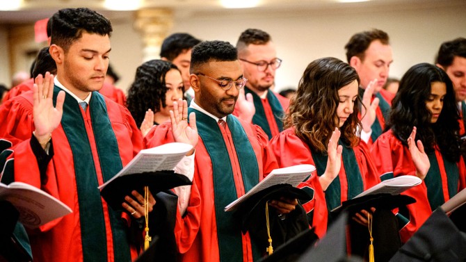 Graduating medical students take the Hippocratic Oath at the ceremony.