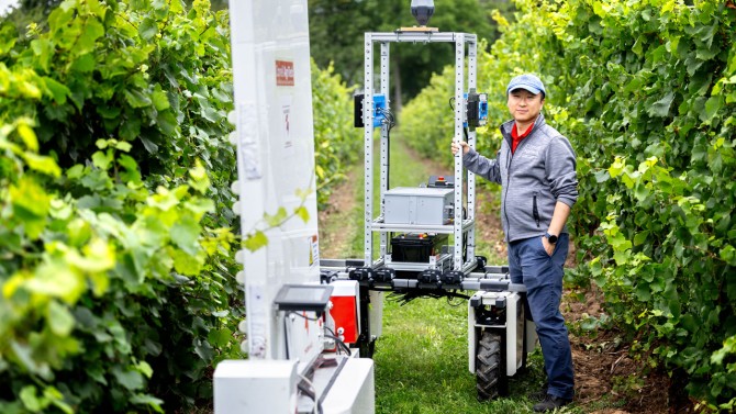 Yu Jiang poses with the  PhytoPatholoBotas as part of the “Space for Ag Tour” at the Cornell Agritech campus.