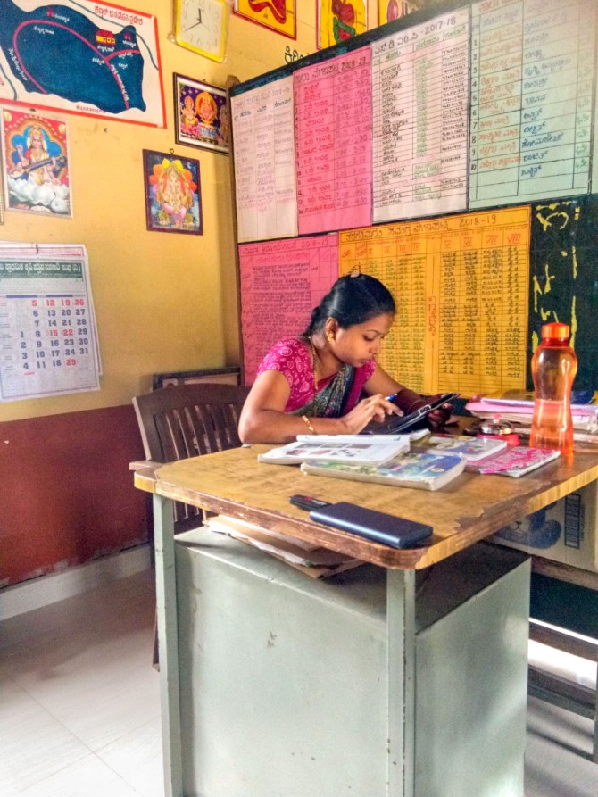 A teacher in a low-income school using smartphone to prepare for her class.