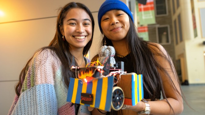 Team Shizzbot, Lindsey Gigliello ’24, left, and Stacey Espiritu ’24 proudly hold their entry in the annual robotics competition.