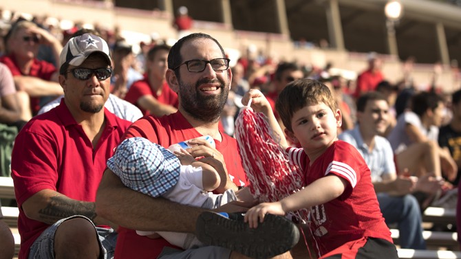 Joshua Novikoff watches football with sons Sam and Liam.