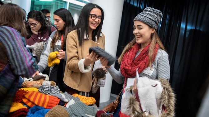 students pick up knitted clothes