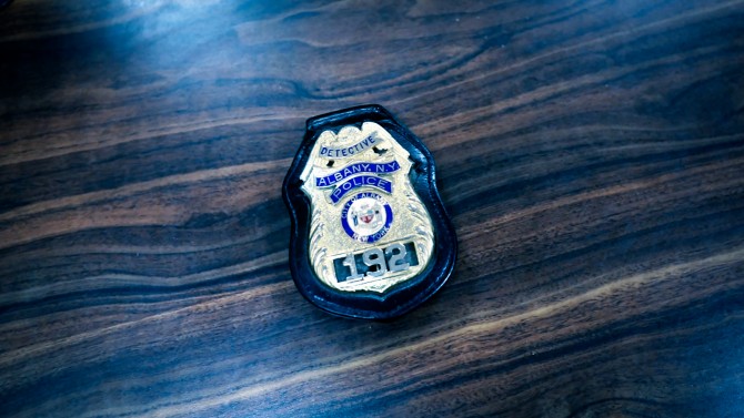 Albany police badge on wooden table