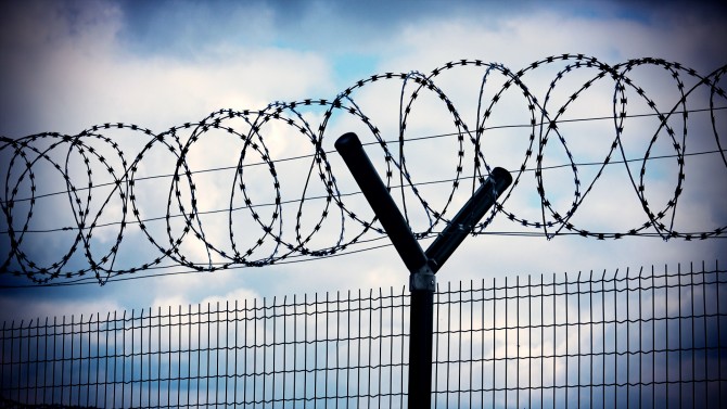 Barbed wire atop fence