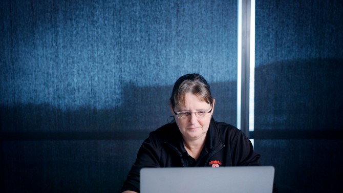 A female professor works on a laptop