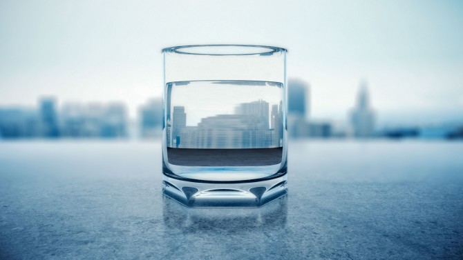 A glass of water in front of a city skyline