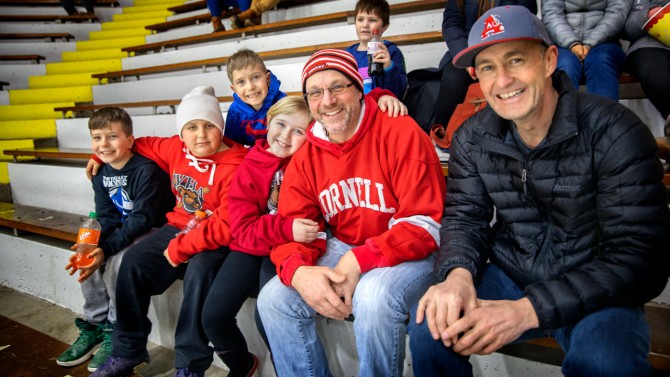 Scott Campbell (far right) and Chris Ford enjoy women’s ice hockey with youngsters.