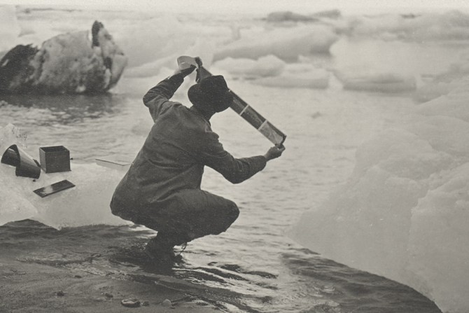 Man on rocks near ice bergs