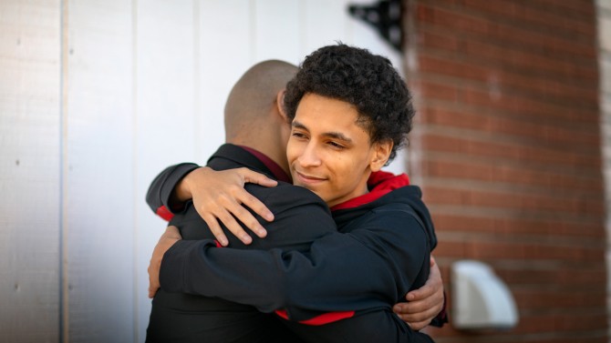 A father and son hug