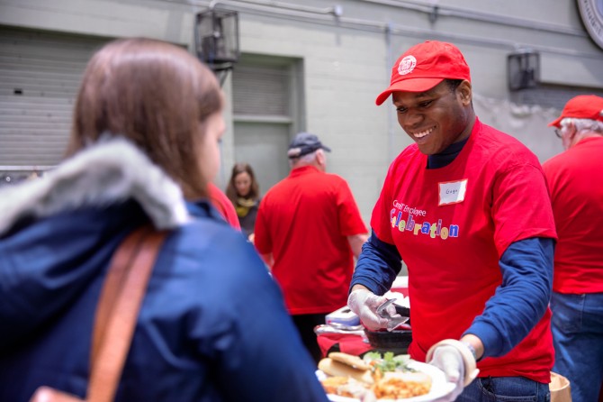 Volunteer serves chicken parmesan