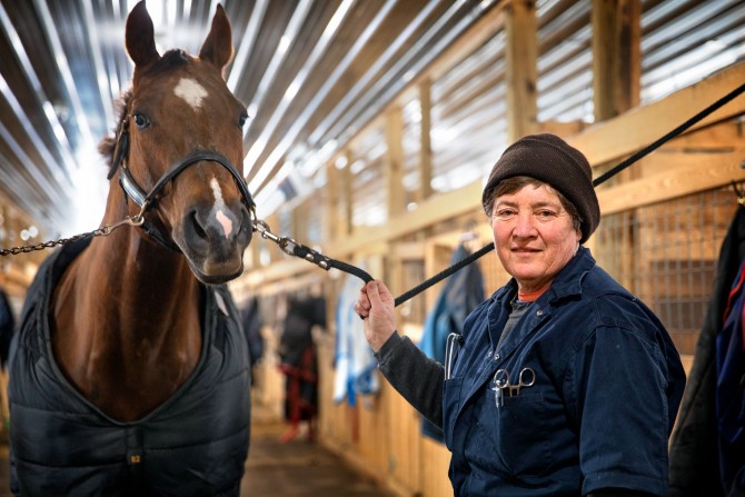 Dr. Barbara Mix, DVM ’82, stops by a stable near Horseheads, New York, to check on an injured show horse