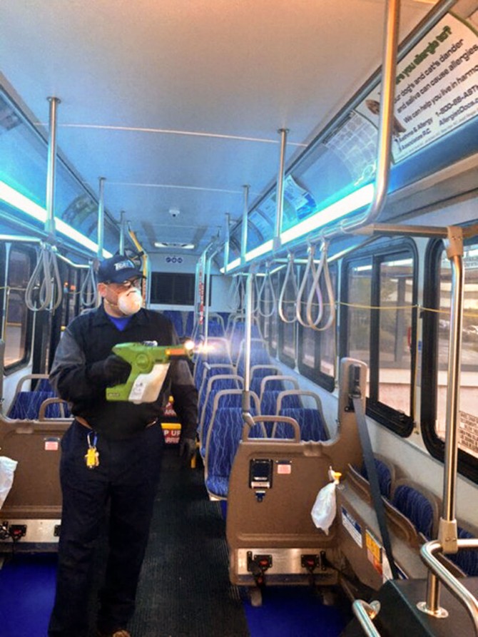 TCAT employee sprays inside of bus with germicide
