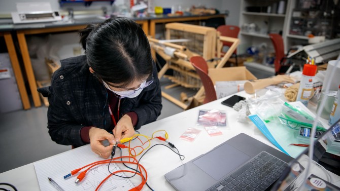 Student in lab with laptop and wires