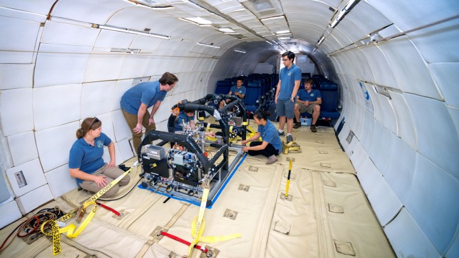 Laura Jones-Wilson, Ph.D. ’12, left, helps prepare a microgravity experiment aboard an aircraft that simulates weightlessness.