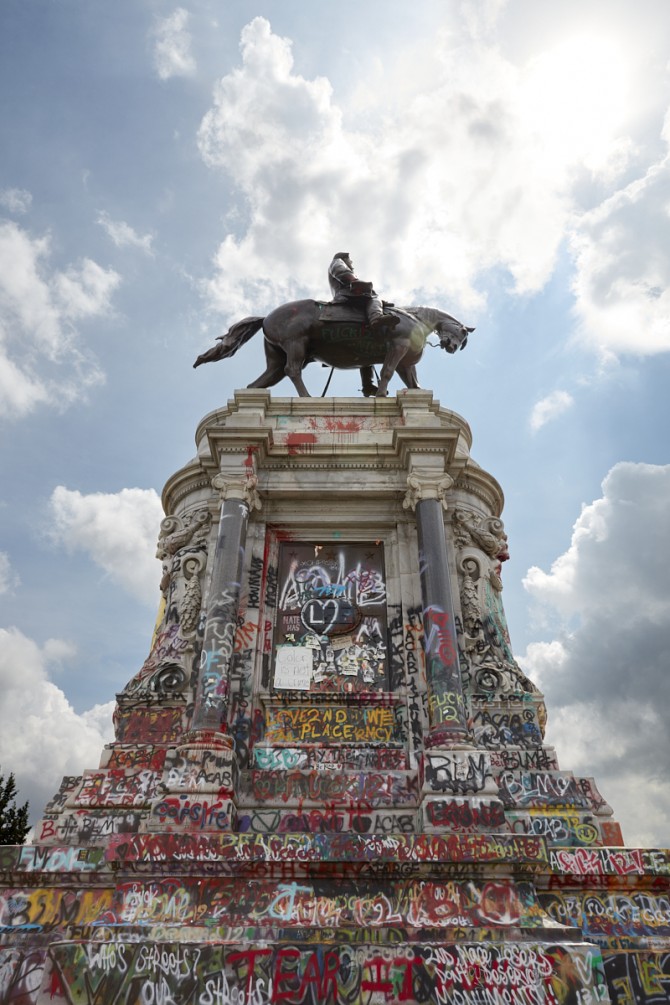 A monument covered in spray painted text.