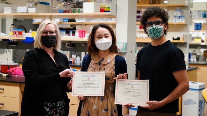 Dr. Deb Fowell presenting Drs Sohyoung Lee and Abbrey Monreal with their Biocytogen Awards