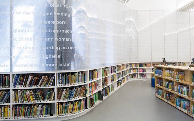 A library with a curved bookcase with an artistic text banner.
