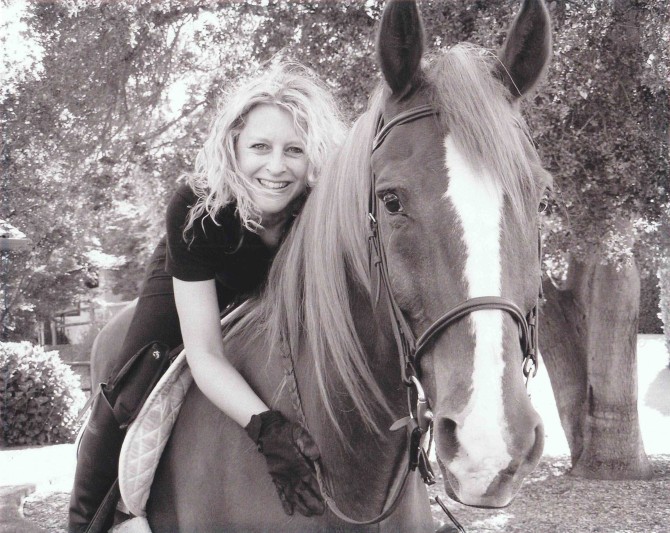 Laura Nowicki riding and embracing a horse